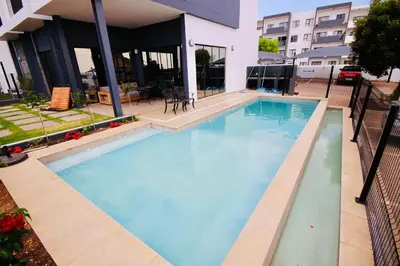 a large blue swimming pool in front of a building at PC Luxe Stays exquisite apartments in Erand