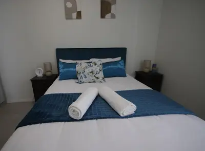a bed with two rolled towels on top of it at PC Luxe Stays exquisite apartments in Erand