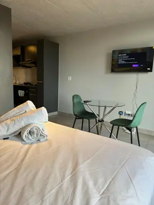 a bedroom with a bed and a table and chairs at Circa apartment hotel in Pretoria