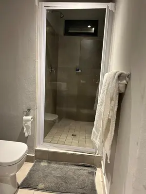 a bathroom with a shower with a toilet and a sink at Circa apartment hotel in Pretoria