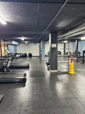 a gym with rows of exercise equipment and a yellow cone at Circa apartment hotel in Pretoria