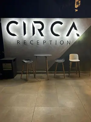 two tables and two chairs in front of a sign at Circa apartment hotel in Pretoria