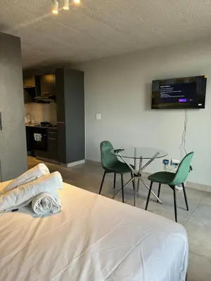 a bedroom with a bed and a table and chairs at Circa apartment hotel in Pretoria