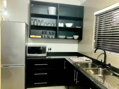a kitchen with a sink and a microwave at Moonlight in Marloth Park