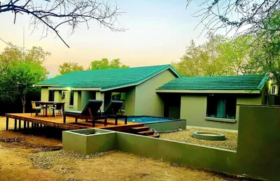 a small house with a deck and a swimming pool at Moonlight in Marloth Park