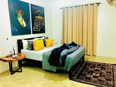 a bedroom with a bed with pillows and a table at Moonlight in Marloth Park