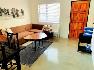 a living room with a couch and a table at Moonlight in Marloth Park