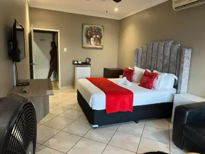 a hotel room with a bed and a television at BY Guest House in Hartbeespoort