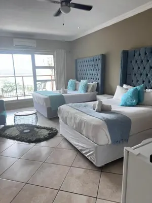 a bedroom with two beds with blue pillows at BY Guest House in Hartbeespoort