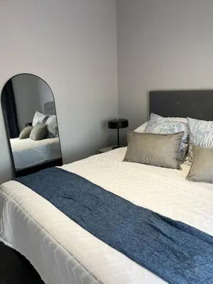 a bedroom with a large bed and a mirror at The Aura at Castle Gate in Pretoria