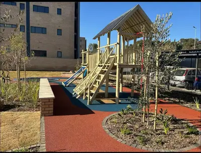 a playground with a slide in front of a building at The Aura at Castle Gate in Pretoria