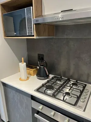 a stove top in a kitchen with a microwave at The Aura at Castle Gate in Pretoria