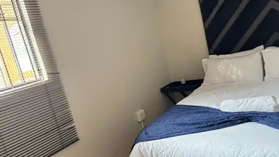 a small bedroom with a bed and a window at The N1 Farm Place in Pretoria