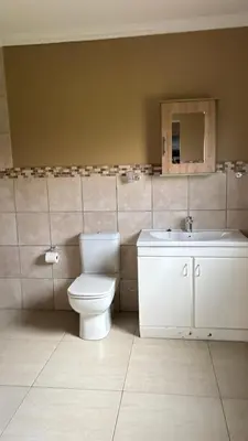 a bathroom with a toilet and a sink at The N1 Farm Place in Pretoria