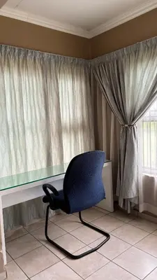 a chair in front of a desk with a window at The N1 Farm Place in Pretoria