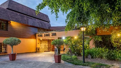 a building with a street light in front of it at African Sky Hotels - Pine Lake Inn in White River