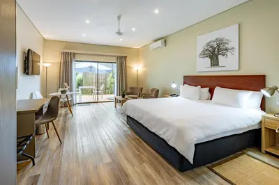 a hotel room with a large bed and a desk at African Sky Hotels - Pine Lake Inn in White River