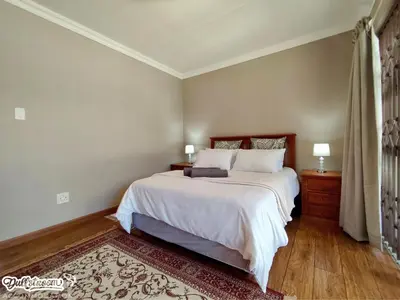 a bedroom with a large bed with white sheets at Central Park in Dullstroom