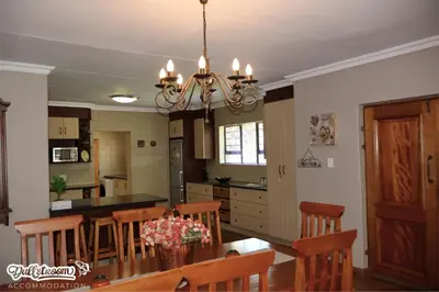 a kitchen and dining room with a table and chairs at Central Park in Dullstroom