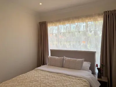 a bed in a bedroom with a large window at 06 Enkeldoring in Pretoria