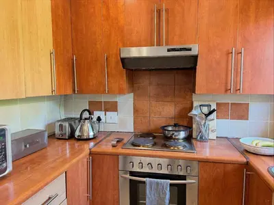 a kitchen with wooden cabinets and a stove top oven at 06 Enkeldoring in Pretoria