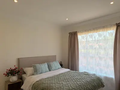 a bedroom with a bed and a large window at 06 Enkeldoring in Pretoria