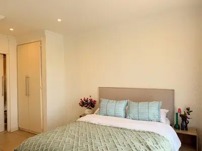 a bedroom with a bed with blue and white pillows at 06 Enkeldoring in Pretoria