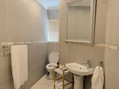 a bathroom with a sink and a toilet and a mirror at 06 Enkeldoring in Pretoria