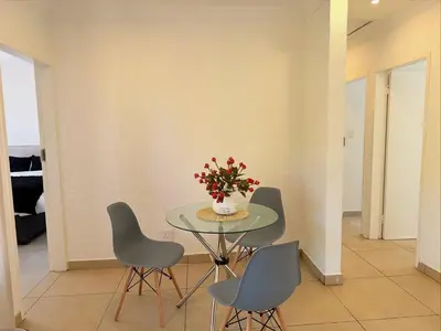 a table with chairs and a vase of flowers on it at 06 Enkeldoring in Pretoria
