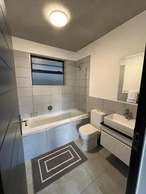 a bathroom with a toilet and a tub and a sink at Midrand Dream Staycation in Midrand