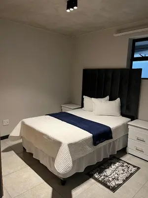 a bedroom with a large bed with a black headboard at Midrand Dream Staycation in Midrand