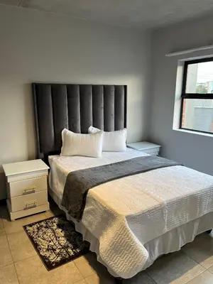 a bedroom with a large bed and a window at Midrand Dream Staycation in Midrand