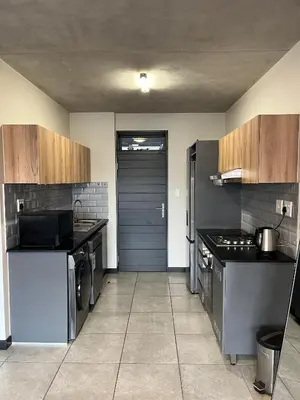 a large kitchen with stainless steel appliances and a door at Midrand Dream Staycation in Midrand
