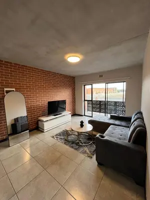 a living room with a couch and a tv at Midrand Dream Staycation in Midrand