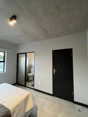 a bedroom with a bed and a bathroom with a toilet at Midrand Dream Staycation in Midrand