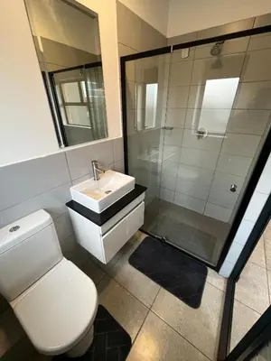 a bathroom with a toilet and a sink and a shower at Midrand Dream Staycation in Midrand