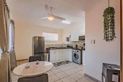 a kitchen with a table and a table and chairs at Upstairs at 47 in Centurion