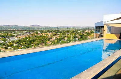 a swimming pool with a view of a city at Menlyn Maine luxury apartments in Pretoria