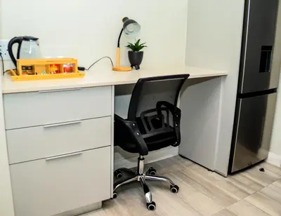 an office desk with a black chair sitting at it at Menlyn Maine luxury apartments in Pretoria