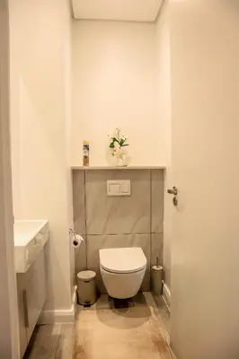 a small bathroom with a toilet and a sink at Menlyn Maine luxury apartments in Pretoria