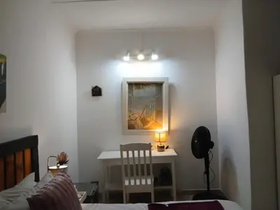 a bedroom with a bed and a desk with a chair at Aero Garden Ensuite in Johannesburg