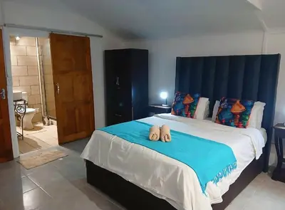 a bedroom with a bed with two towels on it at Aero Garden Ensuite in Johannesburg