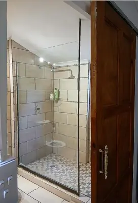 a shower with a glass door in a bathroom at Aero Garden Ensuite in Johannesburg