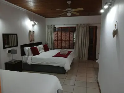 a bedroom with two beds and a ceiling fan at Aero Garden Ensuite in Johannesburg