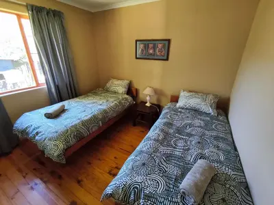 a bedroom with two beds and a window at Fairy Cabin in Dullstroom