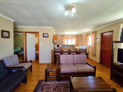 a living room with a couch and chairs and a table at Fairy Cabin in Dullstroom