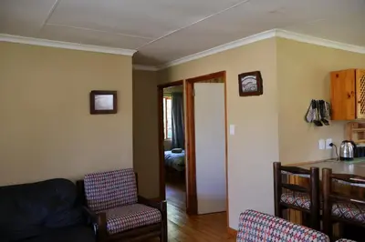 a living room with a couch and a table at Fairy Cabin in Dullstroom
