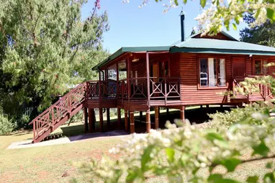 a wooden cabin with a deck and a porch at Fairy Cabin in Dullstroom