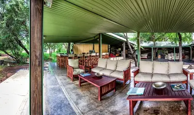 an outdoor patio with couches and tables and a bar at Honeyguide Tented Safari Camp - Khoka Moya in Manyeleti Game Reserve