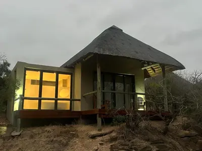 a small house with a thatched roof at Cheetah Paw Safari Lodge in Guernsey Nature Reserve